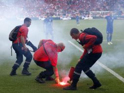 El árbitro detuvo el encuentro hasta que las luces fueron apagadas, mientras la policía buscó en las tribunas a quienes las lanzaron. EFE / R. Ghement