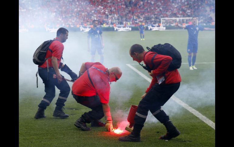 El árbitro detuvo el encuentro hasta que las luces fueron apagadas, mientras la policía buscó en las tribunas a quienes las lanzaron. EFE / R. Ghement