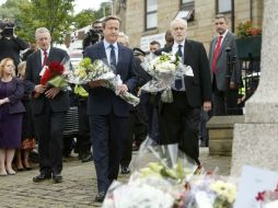 David Cameron (centro), Hilary Benn (izquierda), parlamentario laborista y Jeremy Corbyn, líder laborista, depositan flores en Birstall AP / D. Lawson