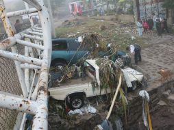 En la colonia Indígena de Mezquitán el agua del canal se desbordó y arrastró dos vehículos hacia un puente peatonal. ESPECIAL / Bomberos de Zapopan