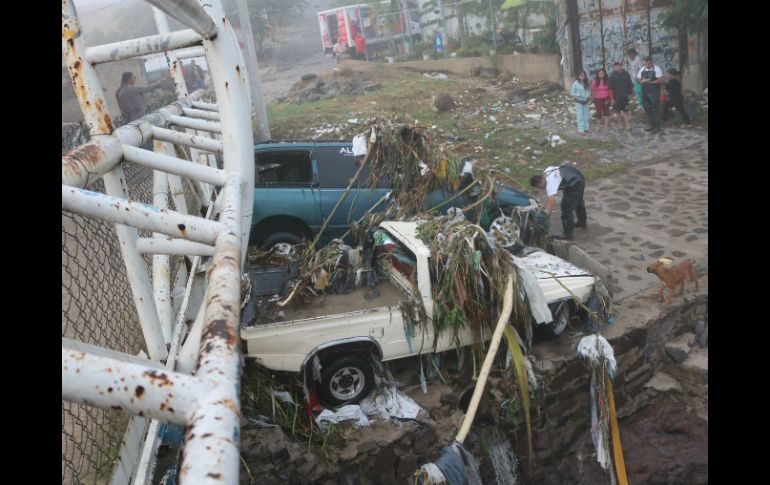 En la colonia Indígena de Mezquitán el agua del canal se desbordó y arrastró dos vehículos hacia un puente peatonal. ESPECIAL / Bomberos de Zapopan