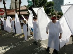 Voluntarios del Teatro Shakespeare de Orlando, vestidos de ángeles, mostraron solidaridad al bloquear la vista a los protestantes. AP / J. Raoux