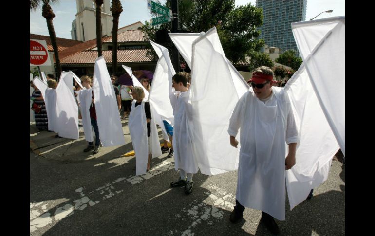 Voluntarios del Teatro Shakespeare de Orlando, vestidos de ángeles, mostraron solidaridad al bloquear la vista a los protestantes. AP / J. Raoux