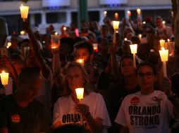 50 mil personas participaron portando velas y banderas arcoiris y de EU, junto con flores blancas. AFP / S. Platt