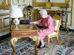 En la instantánea se ve a la monarca en una mesa de una de las salas del castillo de Windsor ataviada con un vestido rosa. TWITTER / @RoyalFamily