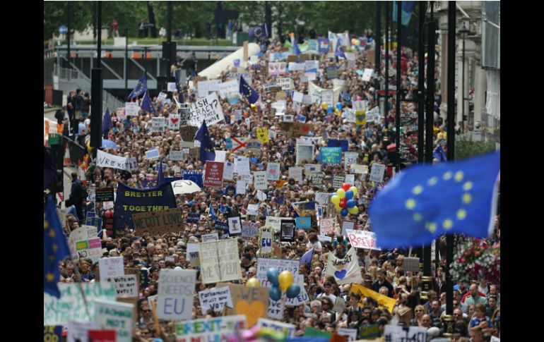 Banderas de la Unión Europea y pancartas salpican la marcha; se pueden leer eslóganes como 'La campaña del 'leave' ha mentido'. AP / D. Leal-Olivas