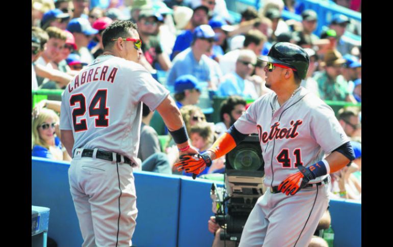 El venezolano Víctor Martínez (derecha), celebra su home run con su compañero de los Tigres de Detroit, Miguel Cabrera. AP /