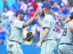 Festejo. Adam Rosales (izquierda) celebra la victoria con sus compañeros de equipo. AFP / T. Szczerbowski