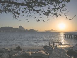 Un grupo de personas se ejercita, mientras disfruta del espectacular amanecer en Copacabana. AP / F. Dana