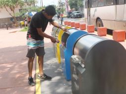 Un ciudadano deposita basura en uno de los contenedores adecuados para la separación y reciclaje de residuos. EL INFORMADOR / A. Hinojosa