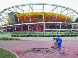 Centro Olímpico de Tenis. Un trabajador ajusta las baldosas del piso del Estadio Olímpico de Río de Janeiro. AP /