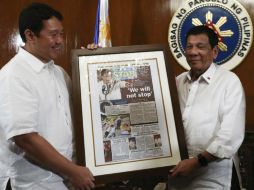 Rodrigo Duterte y el presidente del periódico Philippine Star sostienen una primera página del diario con el titular 'No pararemos'. EFE /