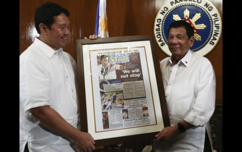 Rodrigo Duterte y el presidente del periódico Philippine Star sostienen una primera página del diario con el titular 'No pararemos'. EFE /