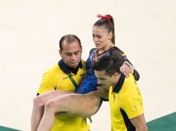 La gimnasta, que aún debía competir en su mejor especialidad, es retirada en brazos de sus entrenadores. MEXSPORT / M. Machado