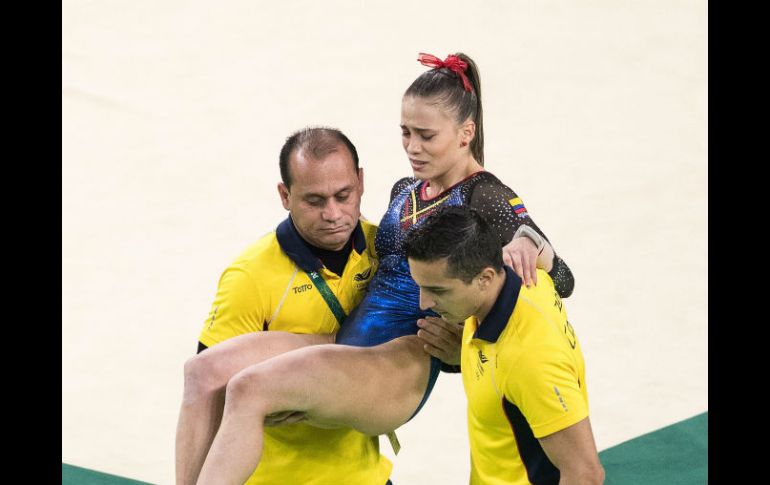 La gimnasta, que aún debía competir en su mejor especialidad, es retirada en brazos de sus entrenadores. MEXSPORT / M. Machado