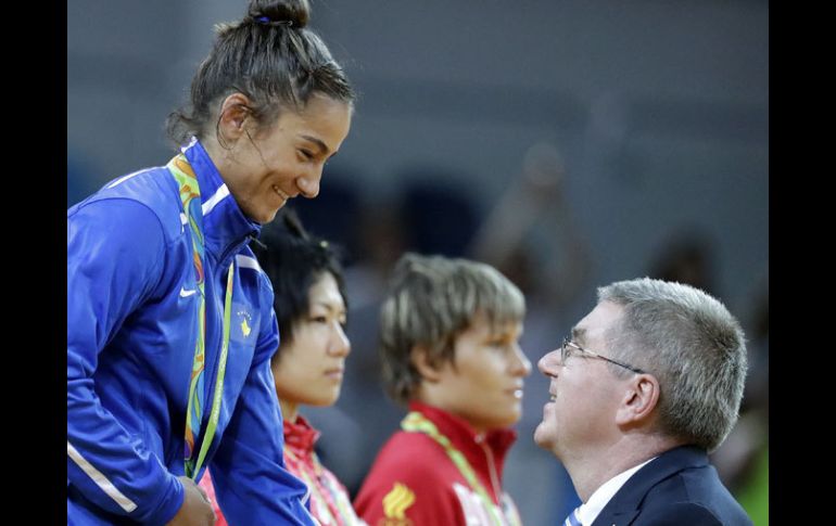 Thomas Bach saludando a una atleta. AP / S.Riedel