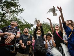 Los participantes guardaron un minuto de silencio en homenaje a los fallecidos y soltaron palomas como símbolo de paz. EFE / C. Jue