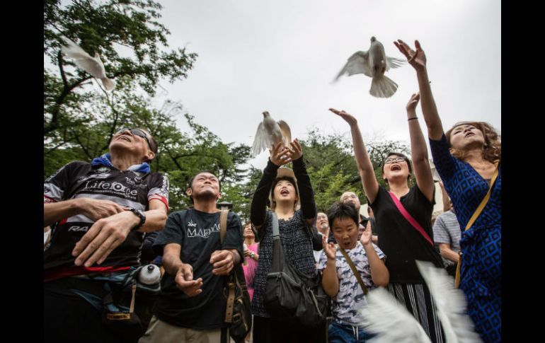 Los participantes guardaron un minuto de silencio en homenaje a los fallecidos y soltaron palomas como símbolo de paz. EFE / C. Jue