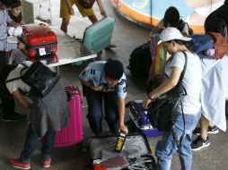 Agentes de seguridad registran a pasajeros a la entrada de la estación de trenes de Bangkok. EFE / N. Sangnak