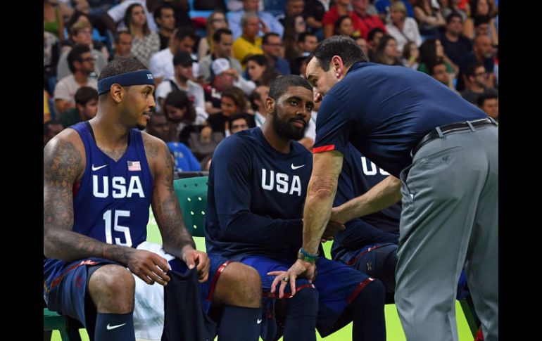 Carmelo (izq) platicando con el entrenador Krzyzewski (pantalón) en Río 2016. AFP / A.Isakovic