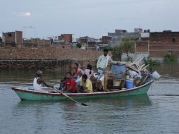 Una familia trata de trasladarse a una zona segura con todas sus pertenencias a bordo de una barcaza. AP / R. Kumar