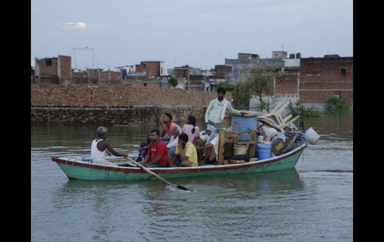 Una familia trata de trasladarse a una zona segura con todas sus pertenencias a bordo de una barcaza. AP / R. Kumar