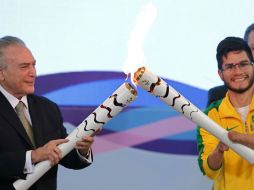 Temer entregó la antorcha al velocista paralímpico Yohansson Nascimento, quien se consagró con la medalla de oro en Londres 2012. AP / E. Peres