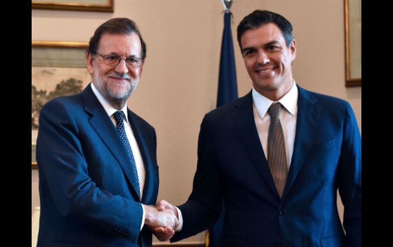 Mariano Rajoy saluda a Pedro Sánchez, líder del PSOE, en una reunión previa al inicio del debate de investidura. AFP / G. Julien