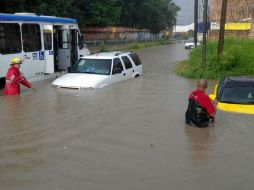 En el cruce de las calles Hilo Amarillo e Hilo Negro, un camión de la ruta 633 quedó varado por la inundación. ESPECIAL /