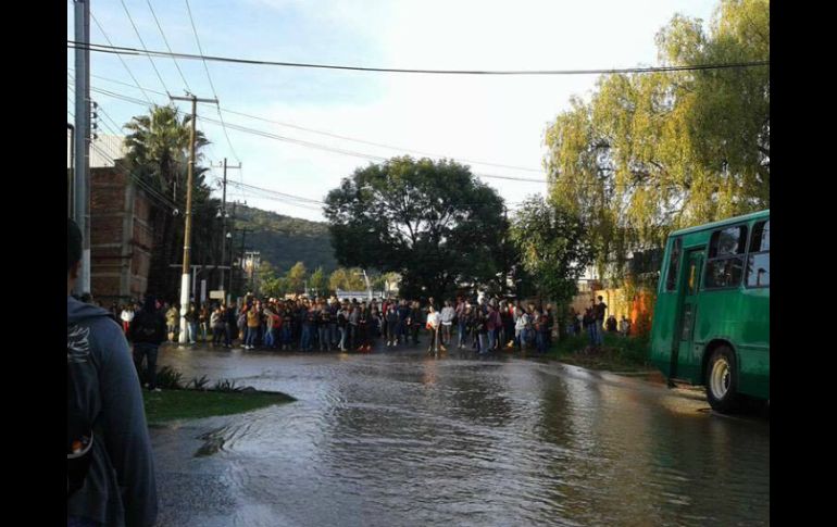 Algunos estudiantes tuvieron que cruzar las calles para arribar al edificio completamente mojados. ESPECIAL /