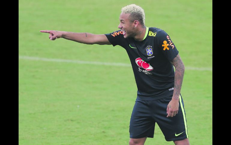 Neymar. El delantero brasileño bromea con un compañero durante el entrenamiento de ayer en el Estadio Arena Amazonía. AP /