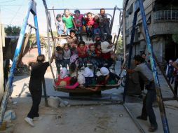 Varios niños se divierten en un parque tras las oraciones de la fiesta del sacrificio. AFP / A. Almohibany