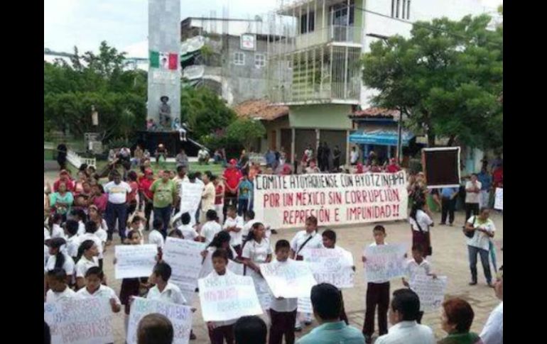 Los niños portan pancartas en las que se lee: 'Viva mi patria' y 'Moderar la opulencia y la indigencia. Nos faltan 43'. TWITTER / @AlbaniaOC