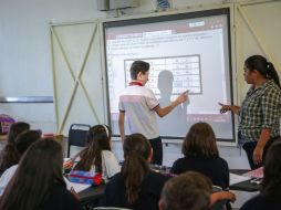 Un estudiante de la Secundaria 24, en Tabachines, utiliza su dedo para anotar la respuesta correcta en la pizarra electrónica. EL INFORMADOR / G. Gallo