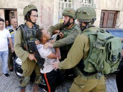 Soldados israelíes detienen a un ciudadano palestino durante un enfrentamiento en Hebrón. EFE / A. Al Hashlamoun