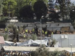 Trabajadores tratan de limpiar el campo de refugiados de Moria en la isla de Lesbos tras un incendio premeditado. EFE / S. Balaskas