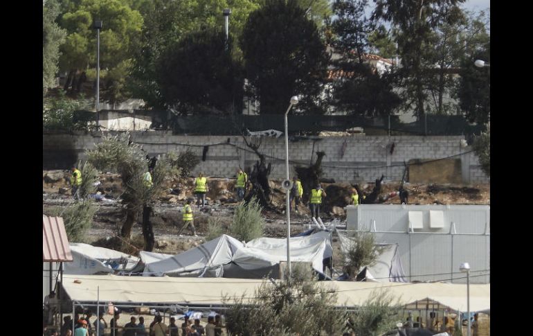 Trabajadores tratan de limpiar el campo de refugiados de Moria en la isla de Lesbos tras un incendio premeditado. EFE / S. Balaskas