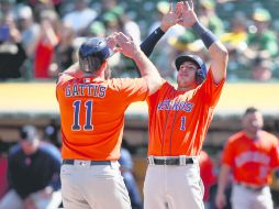 Ganadores. Evan Gattis (11) es felicitado por Carlos Correa tras conectar su segundo cuadrangular. AFP / E. Shaw