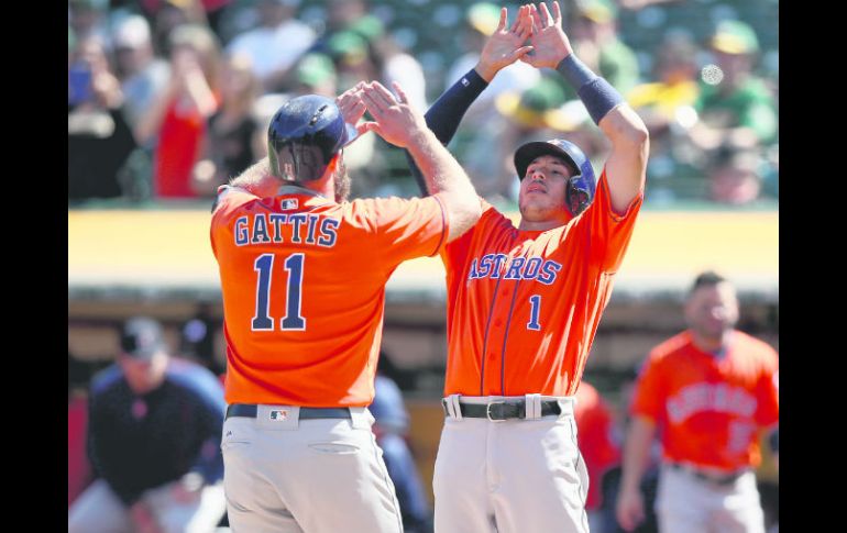 Ganadores. Evan Gattis (11) es felicitado por Carlos Correa tras conectar su segundo cuadrangular. AFP / E. Shaw