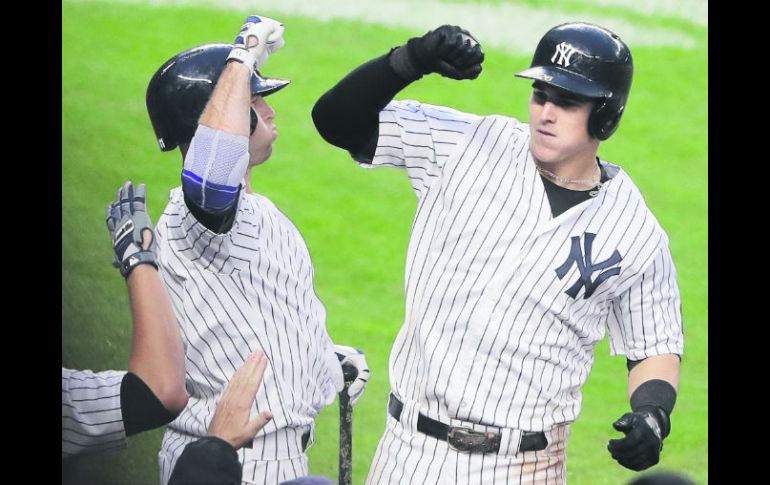 Séptima entrada. Tyler Austin (derecha), de los Yankees, celebra con Mark Teixeira después de pegar un jonrón. AP /