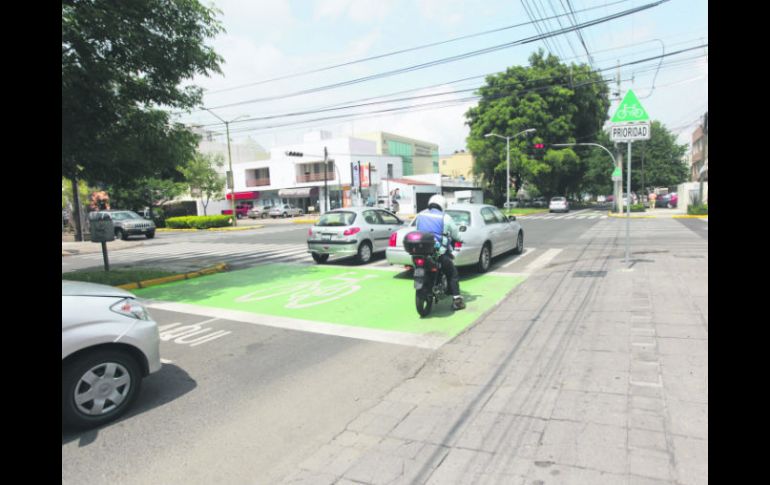 Dos automovilistas y un motociclista invaden la zona peatonal y la exclusiva para cicilistas, en espera de la luz verde. EL INFORMADOR / F. Atilano