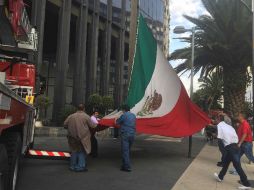 Elementos del cuerpo de bomberos retiran el símbolo patrio. SUN / B. Fregoso