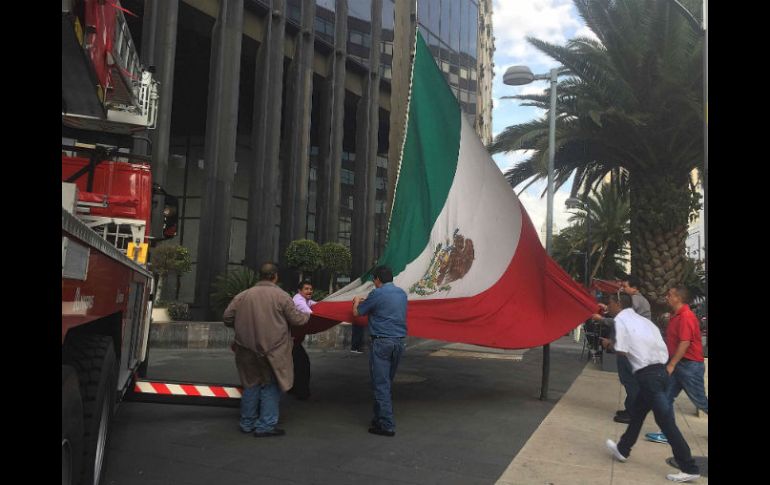 Elementos del cuerpo de bomberos retiran el símbolo patrio. SUN / B. Fregoso