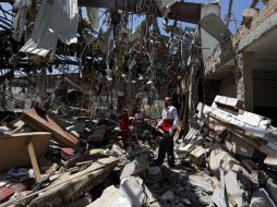 Entre las ruinas del funeral bombardeado, miembros de la Sociedad de la Media Luna Roja buscan sobrevivientes. EFE / Y. Arhab