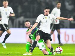 Paso perfecto. El alemán Julian Draxler (#7), y el norirlandés Oliver Norwood (#16) se disputan el balón. AP /