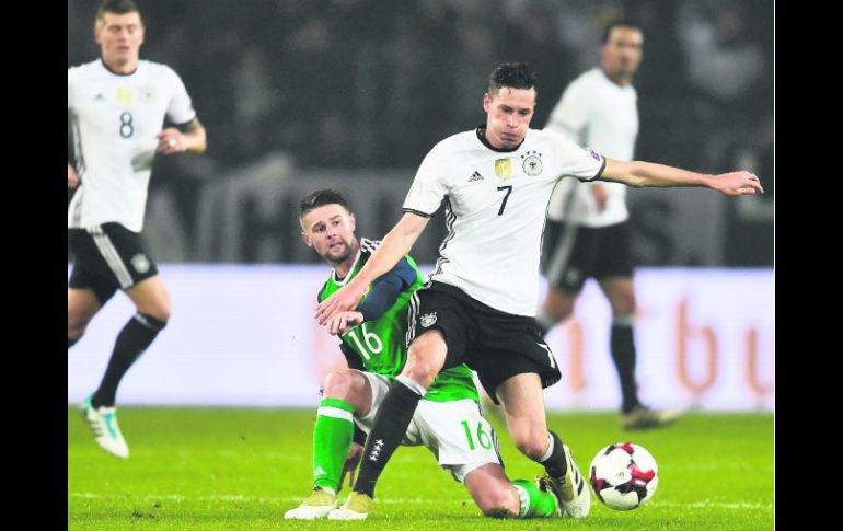 Paso perfecto. El alemán Julian Draxler (#7), y el norirlandés Oliver Norwood (#16) se disputan el balón. AP /