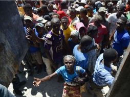 La gente se agolpa ante los camiones del Programa Mundial de Alimentos de la ONU para recibir un poco de arroz. AFP / H. Retamal