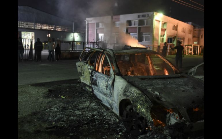 Los restos del auto yacen a las afueras de un campamento de refugiados en Oreokastro. AP / G. PAPANIKOS