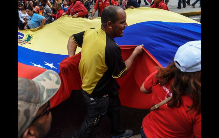 Un grupo de venezolanos llevan la bandera nacional durante una demostración en Caracas. AFP / J. Barreto