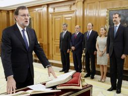 El reelegido presidente del Gobierno, Mariano Rajoy (i), jura el cargo ante el Rey. EFE / A. Díaz